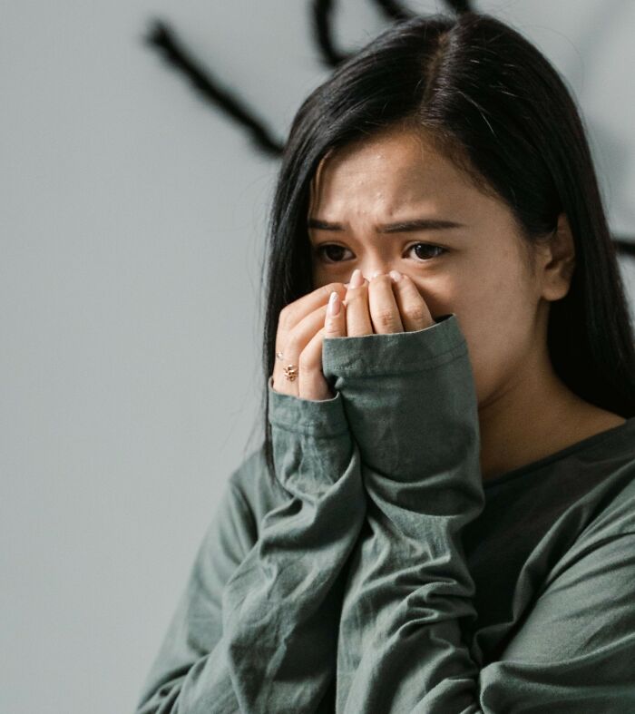 A woman crying, covering her mouth and nose. Therapists often encounter complex emotional challenges.