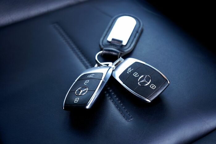 Car keys on a dark leather seat, symbolizing safety tips for women living alone to protect themselves.