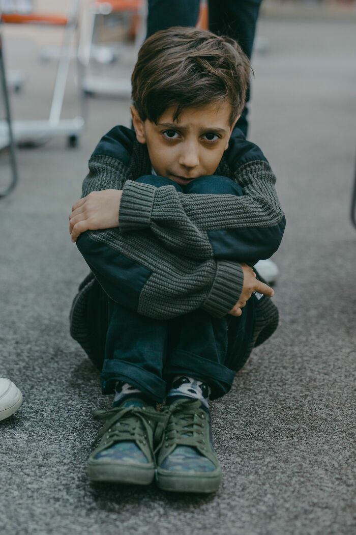 A child looking distressed, perhaps finally opening up to a parent about what they were going through.