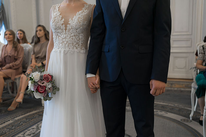 A close-up of a bride and groom holding hands during their wedding ceremony. A close-up of a bride and groom holding hands during their wedding ceremony.