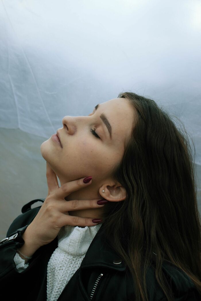 A woman with her eyes closed and a hand on her neck, emphasizing self-protection tips for women living alone.