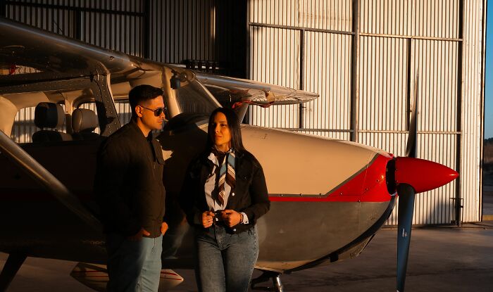 A couple standing by a private airplane hangar, illustrating how rich people travel