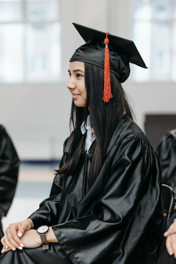 A smiling graduate in cap and gown, representing simple joys of achievement.