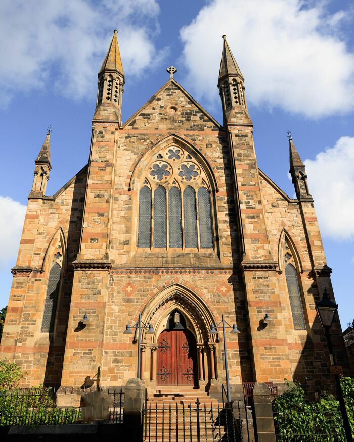 A majestic old stone church with intricate architecture under a blue sky, reflecting simple joys of beauty.