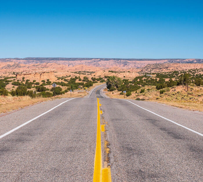 A long, winding road through the scenic New Mexico landscape, symbolizing the journey and identity of the state amidst name change talks. A long, winding road through the scenic New Mexico landscape, symbolizing the journey and identity of the state amidst name change talks.