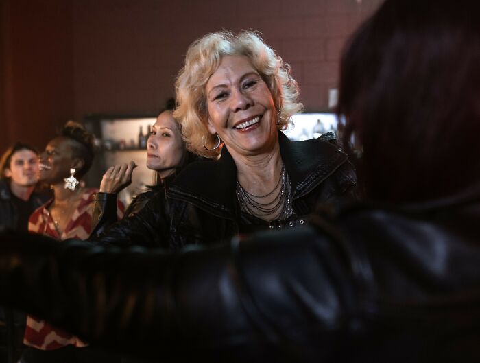 A woman smiling at a party, showcasing social gatherings of rich people