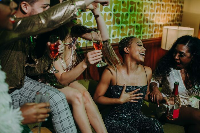 A group of rich people drinking champagne and laughing at a party