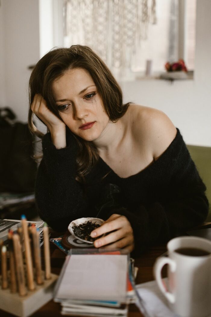 Woman served hot tea, looking sad at a table nearby, with dinner not visible in the restaurant.