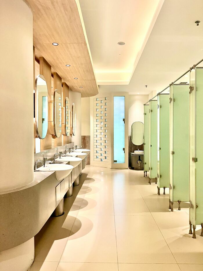A modern public restroom with multiple sinks and stalls, challenging a stereotype about the US.