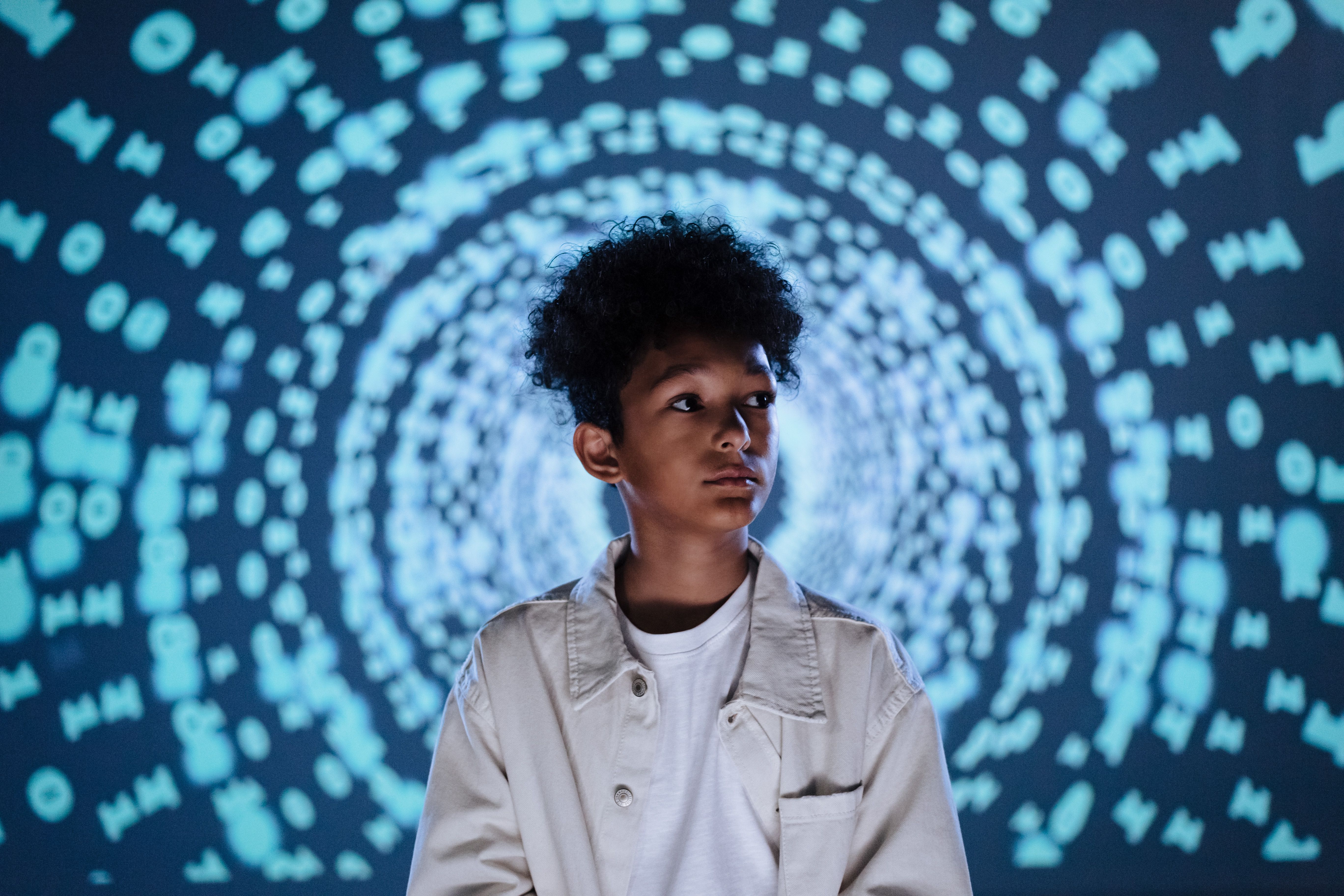 Boy standing in front of swirling blue AI code tunnel