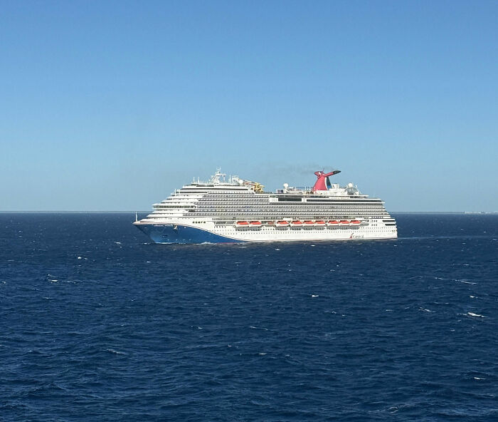 A large cruise ship sailing on open blue water under a clear sky, similar to the anniversary trip vessel A large cruise ship sailing on open blue water under a clear sky, similar to the anniversary trip vessel