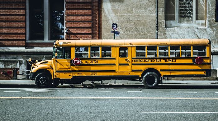 A classic yellow American school bus parked on a street, a familiar US stereotype.