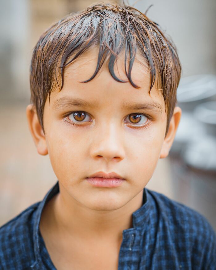 A young child with wet hair and intense eyes, possibly a sociopath, looks directly at the camera.