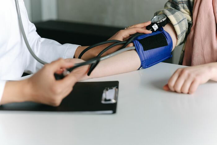 A doctor takes a patient's blood pressure, monitoring health symptoms for a doctor's examination.