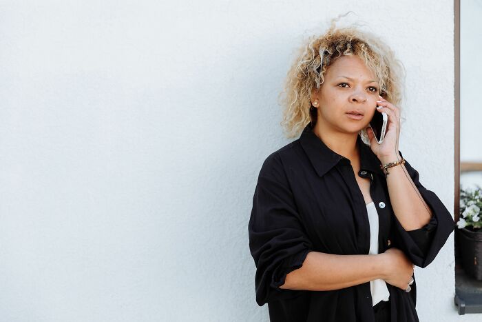 A woman on the phone, looking concerned, likely reacting to lies men told her.
