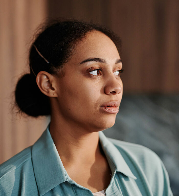 A woman with her hair in a bun looking away, illustrating parents who had no idea what their children were experiencing.