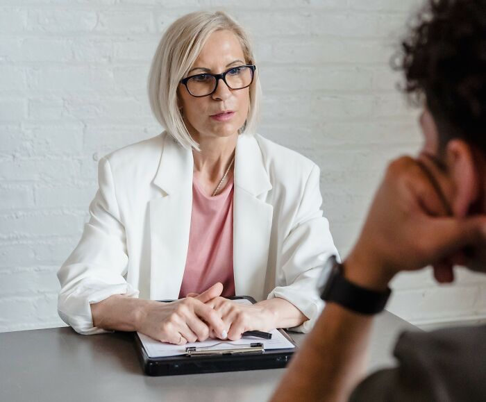 A therapist listens intently to a patient, looking for behavioral patterns that might indicate a sociopath.