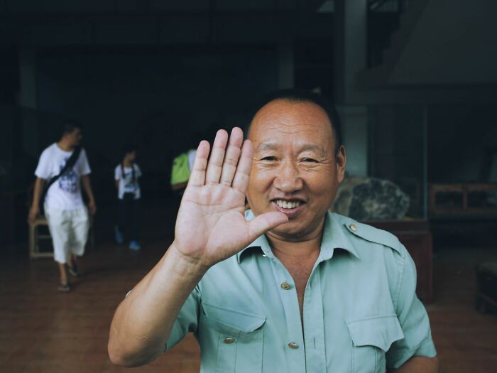 Smiling man waving, representing stereotypes about the US.