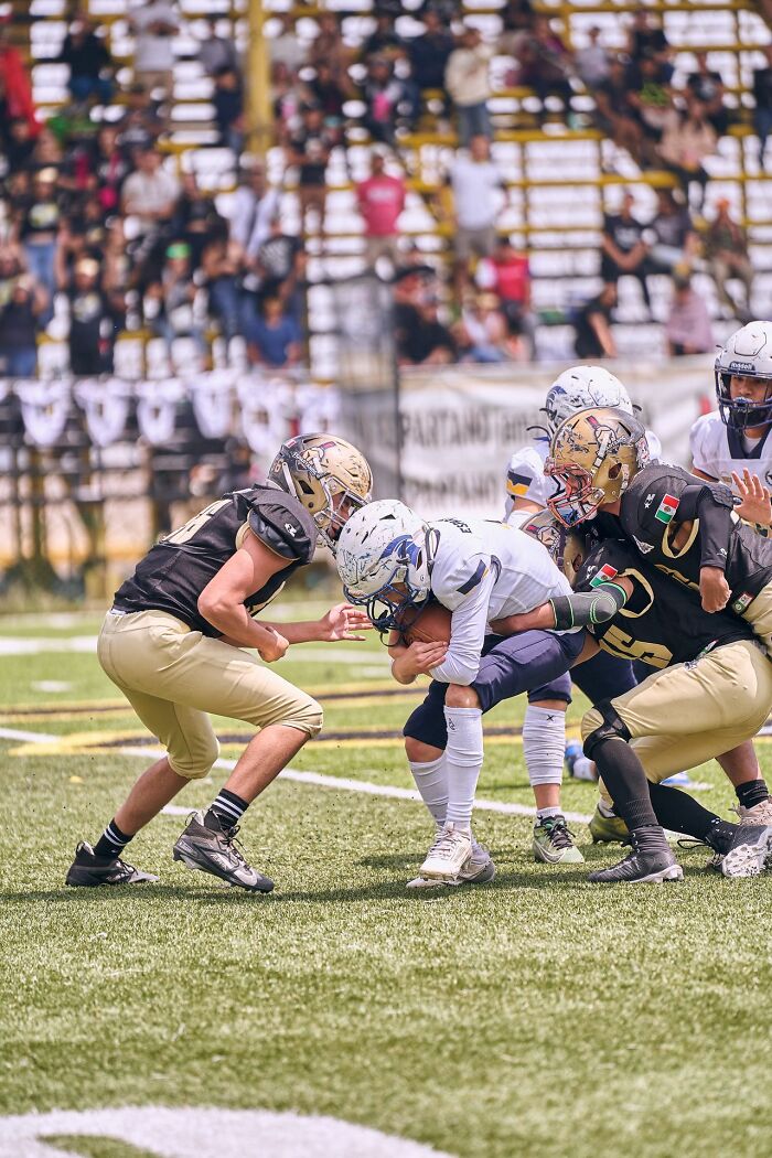American football players in action on a field, showcasing a common US stereotype.