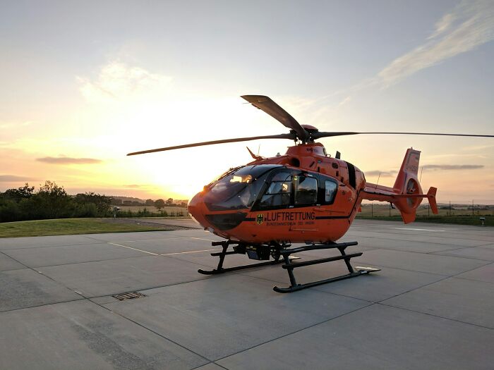 A rescue helicopter at sunset, ready to transport strange patients for medical care