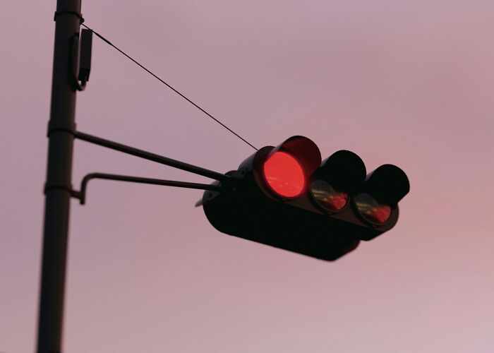 A red traffic light against a twilight sky, highlighting rules and arguments heard in court.