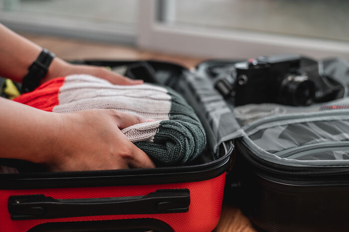 A person packing a suitcase, symbolizing the departure or life changes that can follow divorce and marriages.