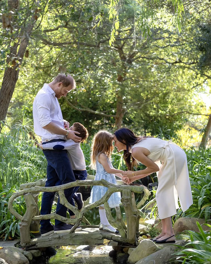 Prince Harry and Meghan Markle with their children, in a garden, after King Charles' controversial letter.