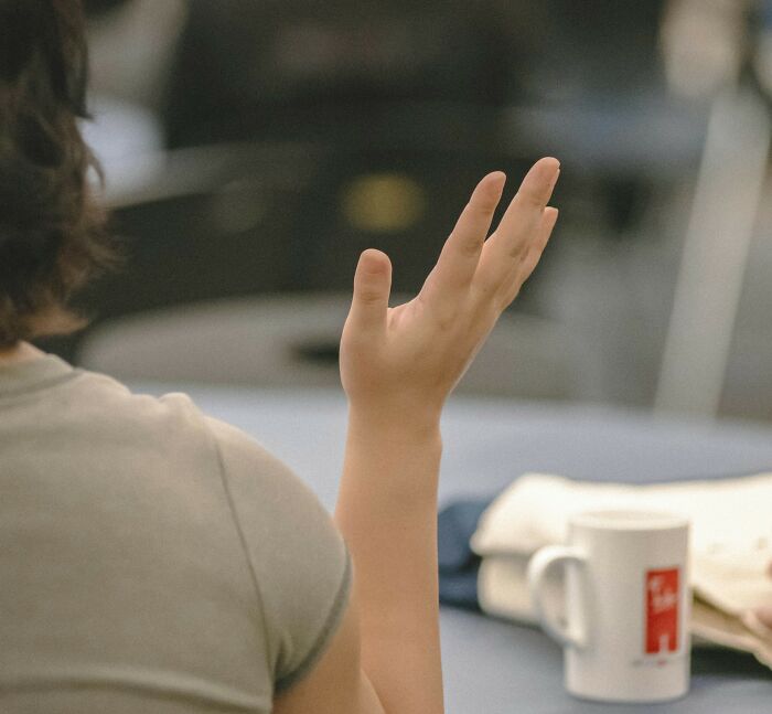 A client raising their hand, possibly asking a stupid question, shocking lawyers.