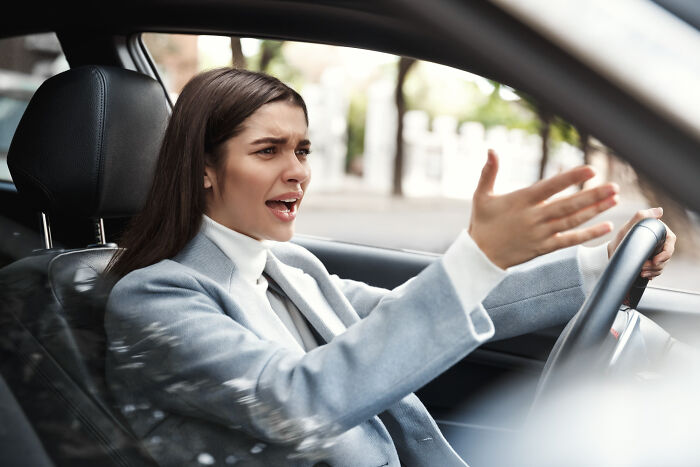 A frustrated road user in a car, emphasizing the impact of speed camera signs and speed limits.