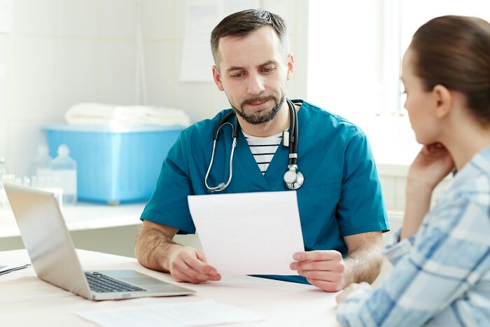 A doctor discussing a medical report with a patient, highlighting a difficult period in marriages.