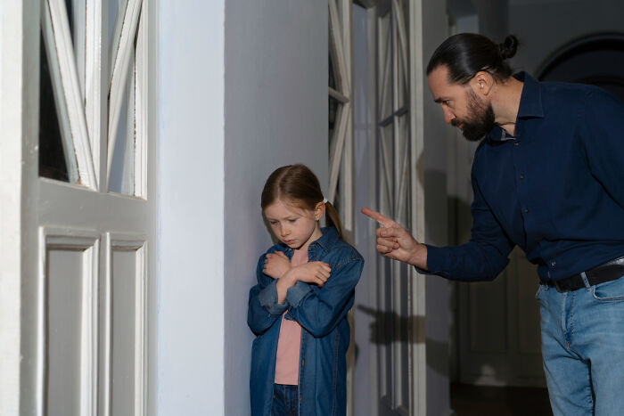 An angry father points at his sad daughter, demonstrating how family conflicts cause marriages collapsed
