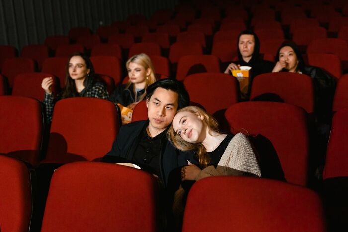A couple sits together in a movie theater, realizing why some marriages collapsed after drifting apart