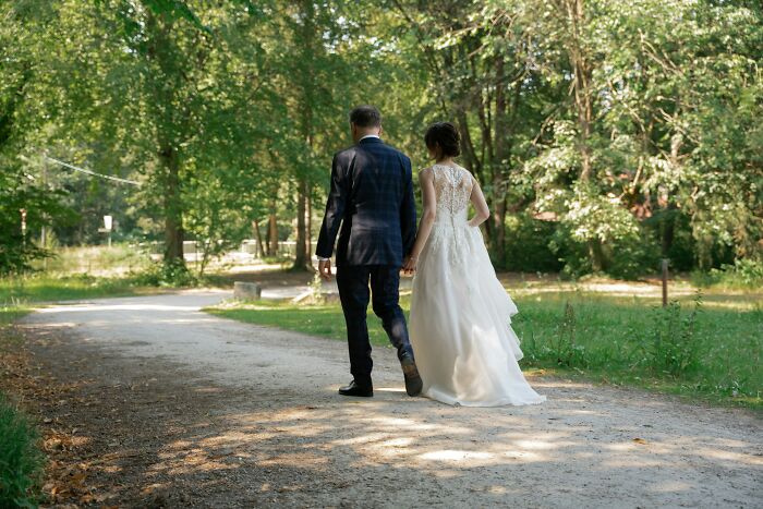 A newlywed couple holding hands and walking down a path, for a story about being called liars for true stories.