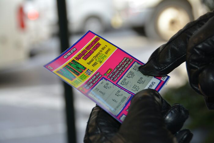 Hands in black gloves scratching a lottery ticket, for a story about being called liars for true stories.