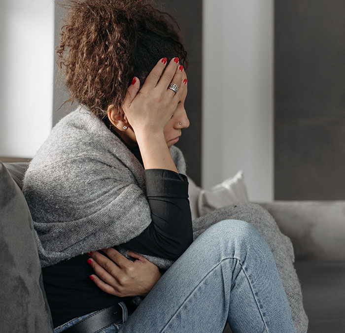 A stressed mother holding her head in frustration, reflecting the tension of MIL to babysit conflict A stressed mother holding her head in frustration, reflecting the tension of MIL to babysit conflict