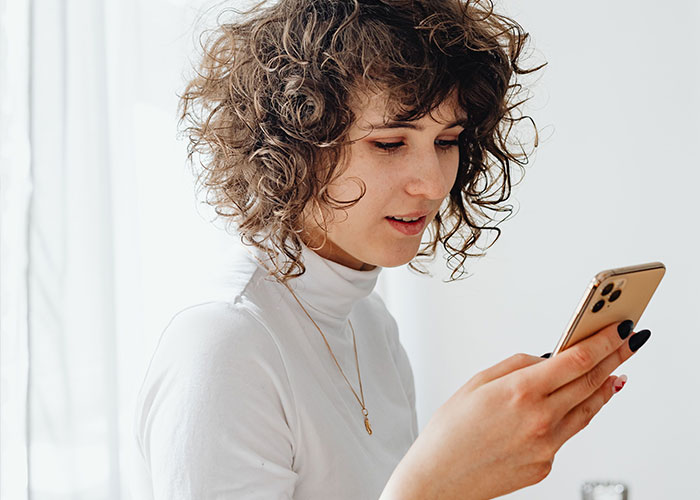 A woman looks at her phone, sharing a weird text she got before a date, a potential warning sign. A woman looks at her phone, sharing a weird text she got before a date, a potential warning sign.