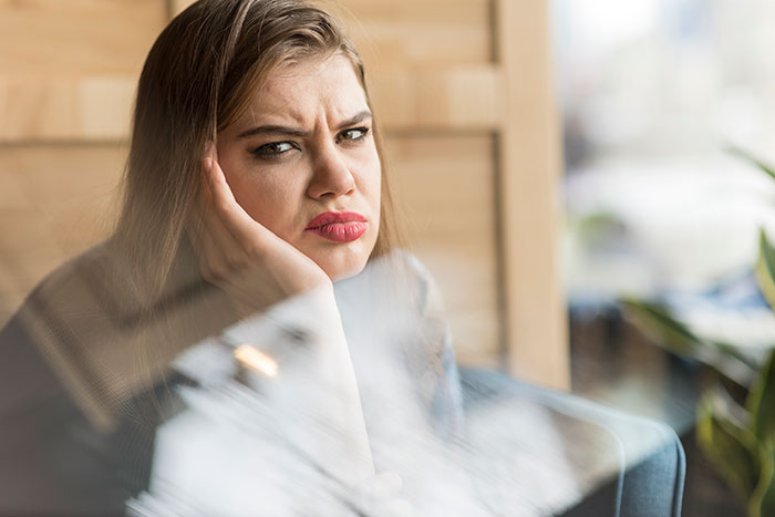 A woman looking irritated and sad, reflecting the frustrations about the nanny and vacation. A woman looking irritated and sad, reflecting the frustrations about the nanny and vacation.