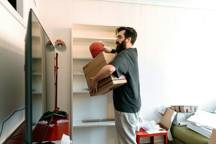 A man packing a box, perhaps moving out after hearing relationship revenge stories