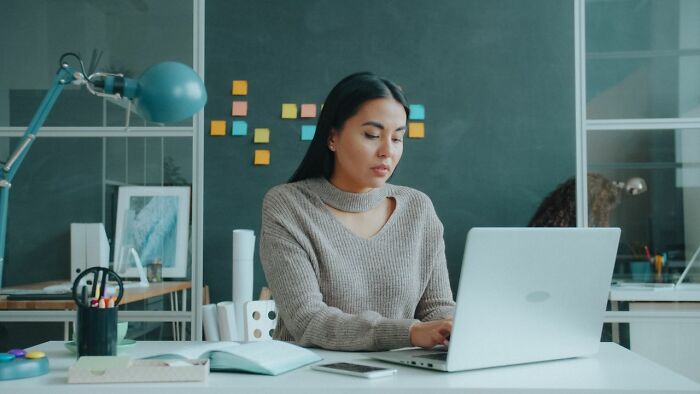 A woman working on a laptop, brainstorming relationship revenge stories