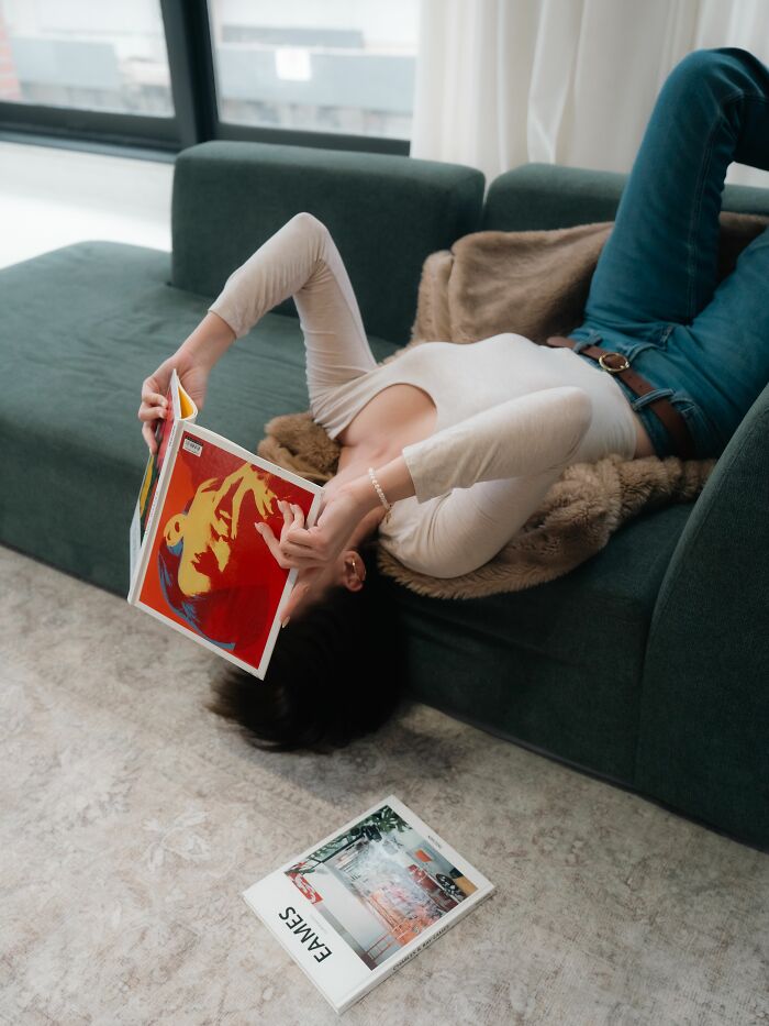 Woman laying on couch covering her face with a book, perfect for relationship revenge stories