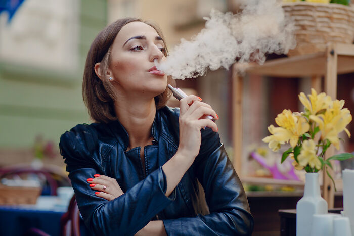 A woman vaping, representing hidden habits that can lead to marriage regrets.