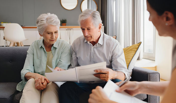 An elderly couple reviewing papers to protect their inheritance while planning future finances. An elderly couple reviewing papers to protect their inheritance while planning future finances.