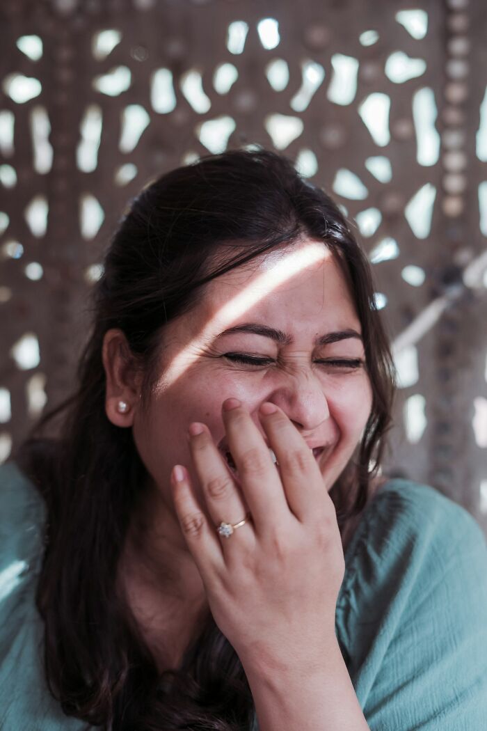 Woman laughing while enjoying delicious dinner and hot tea at a restaurant, expressing joy.
