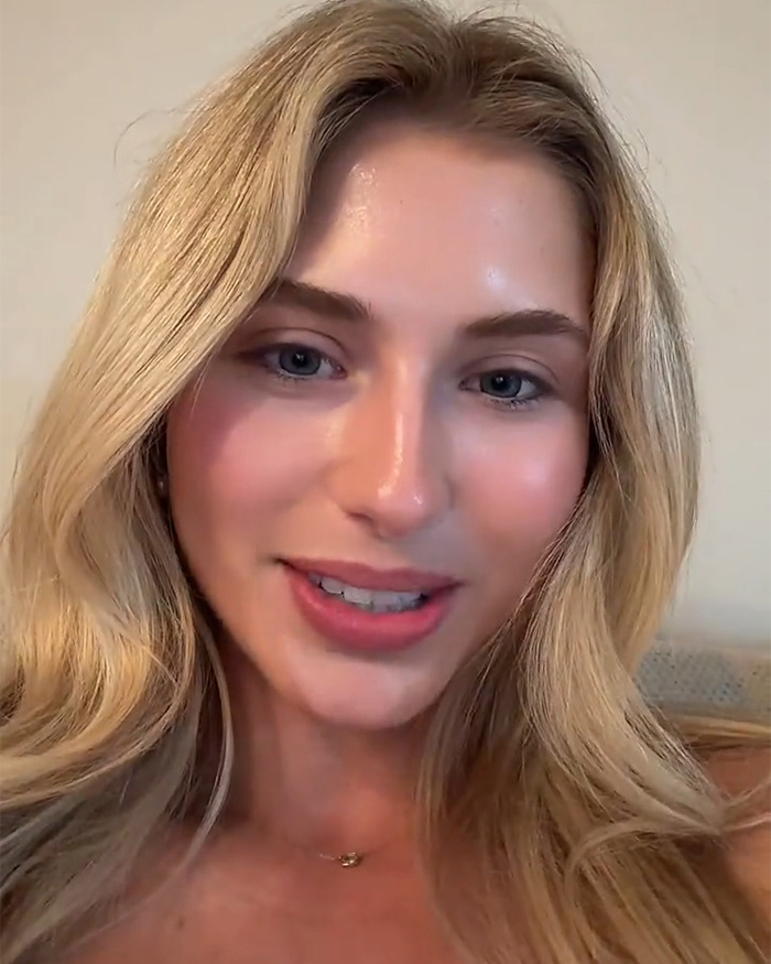An attractive woman with blonde hair, glowing skin, and a necklace, looking directly at the camera.