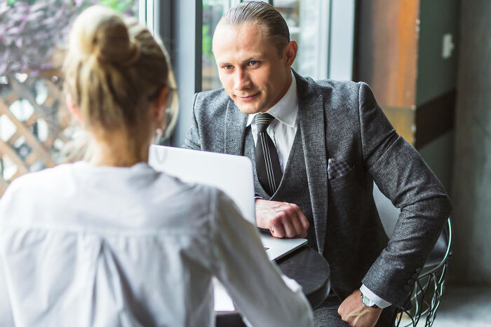 A business professional listening closely during a meeting, showing focused body behaviors