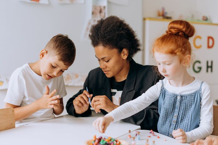 A teacher working closely with children, observing subtle facial expressions and behavioral cues.