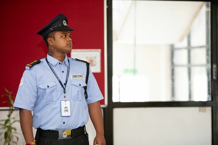 A professional security officer looking observant on duty, highlighting how experts read people and behaviors.
