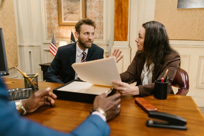 Business professionals holding a meeting and analyzing documents to read people and understand behaviors.