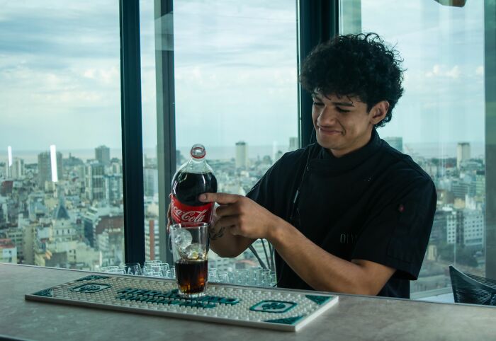 A bartender showing professional behaviors while pouring a drink