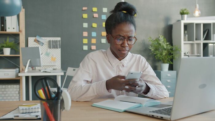 An office worker analyzing behaviors on her mobile phone at her desk